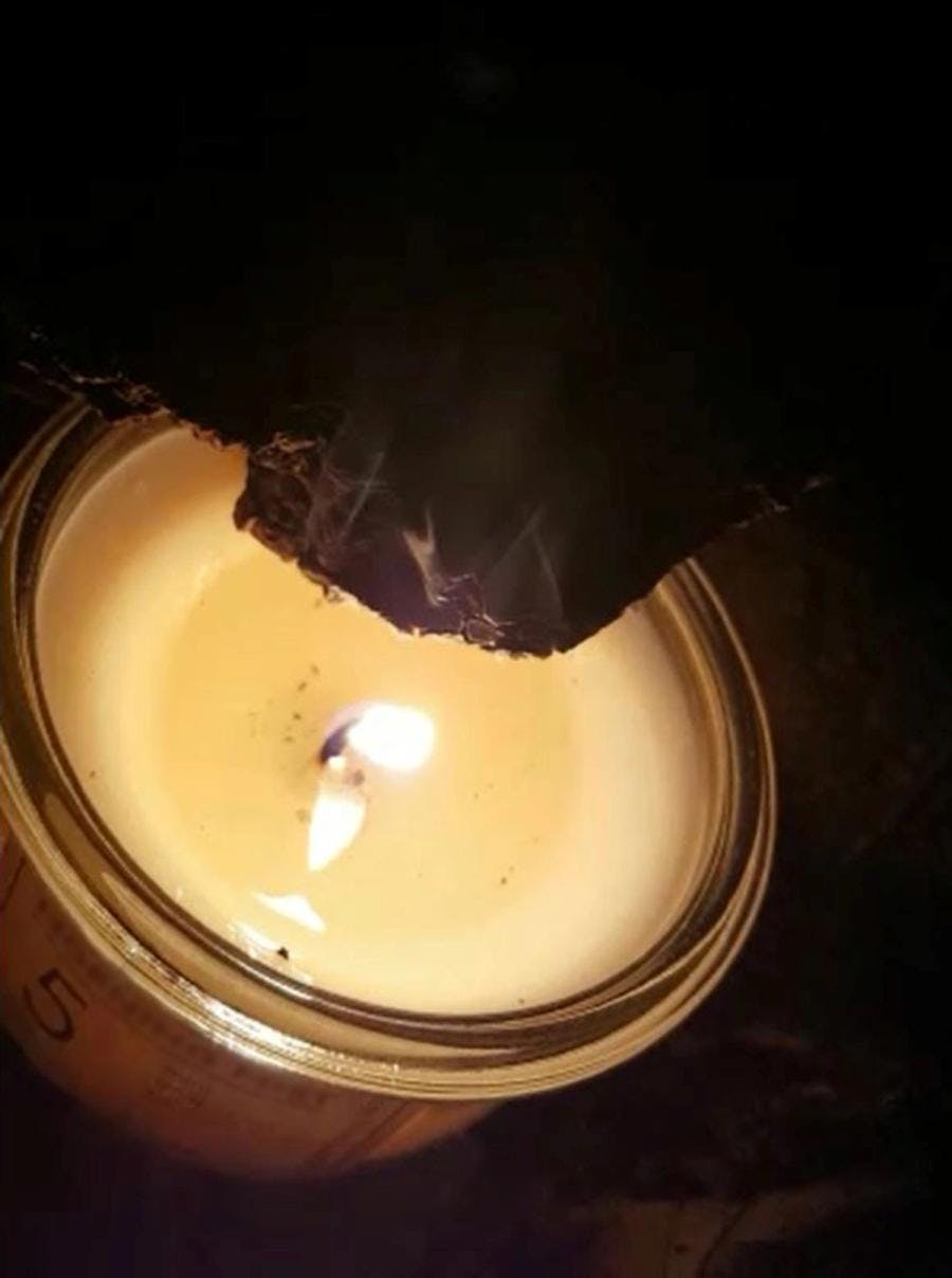 Cork block held up to candle flame to test burn rate