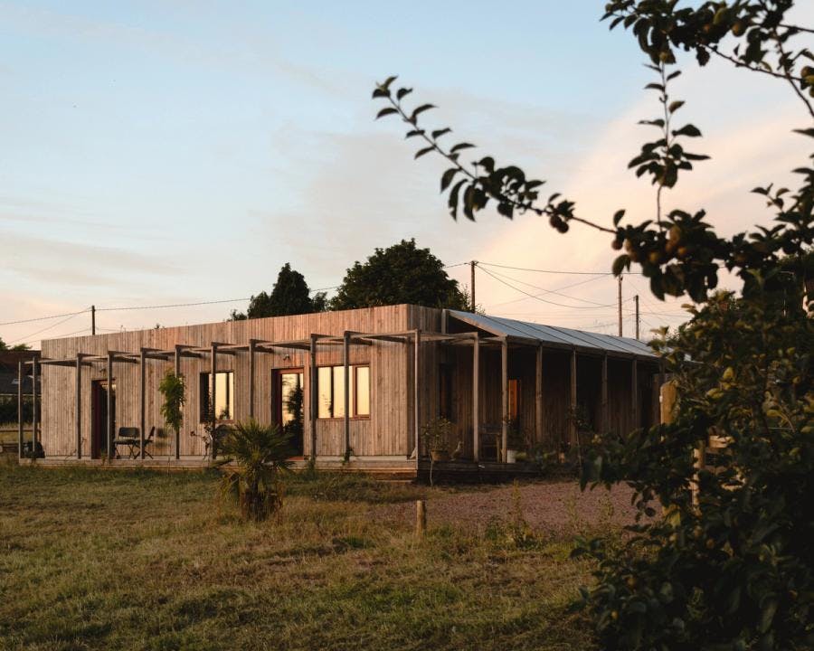 A self-built, single storey timber eco-house at dusk