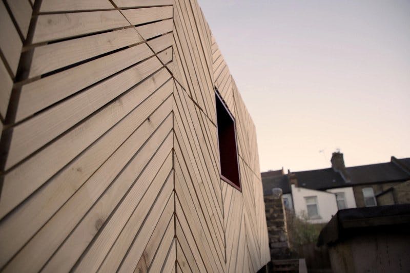 View of diagonal timber slat patterns that make up garden shed cladding