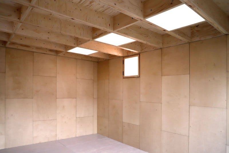 Internal view of unfurnished garden shed made with modular boxes and skylights