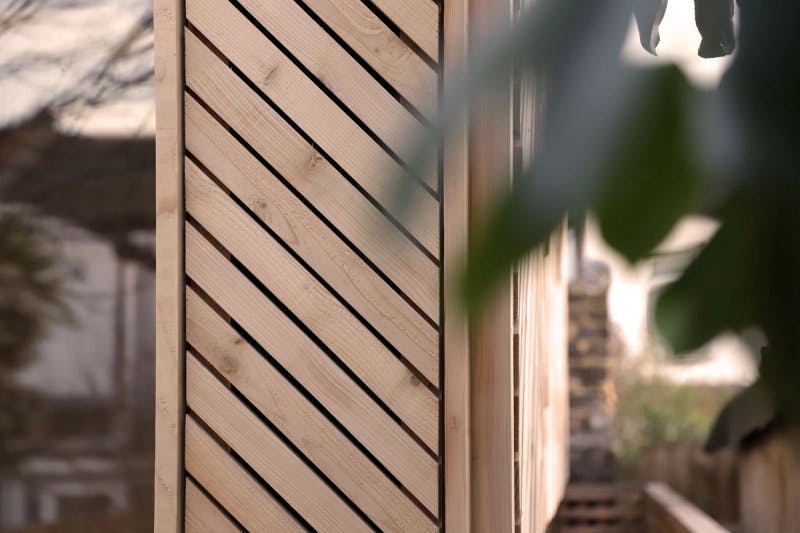 View of diagonal timber slats that make up garden shed cladding