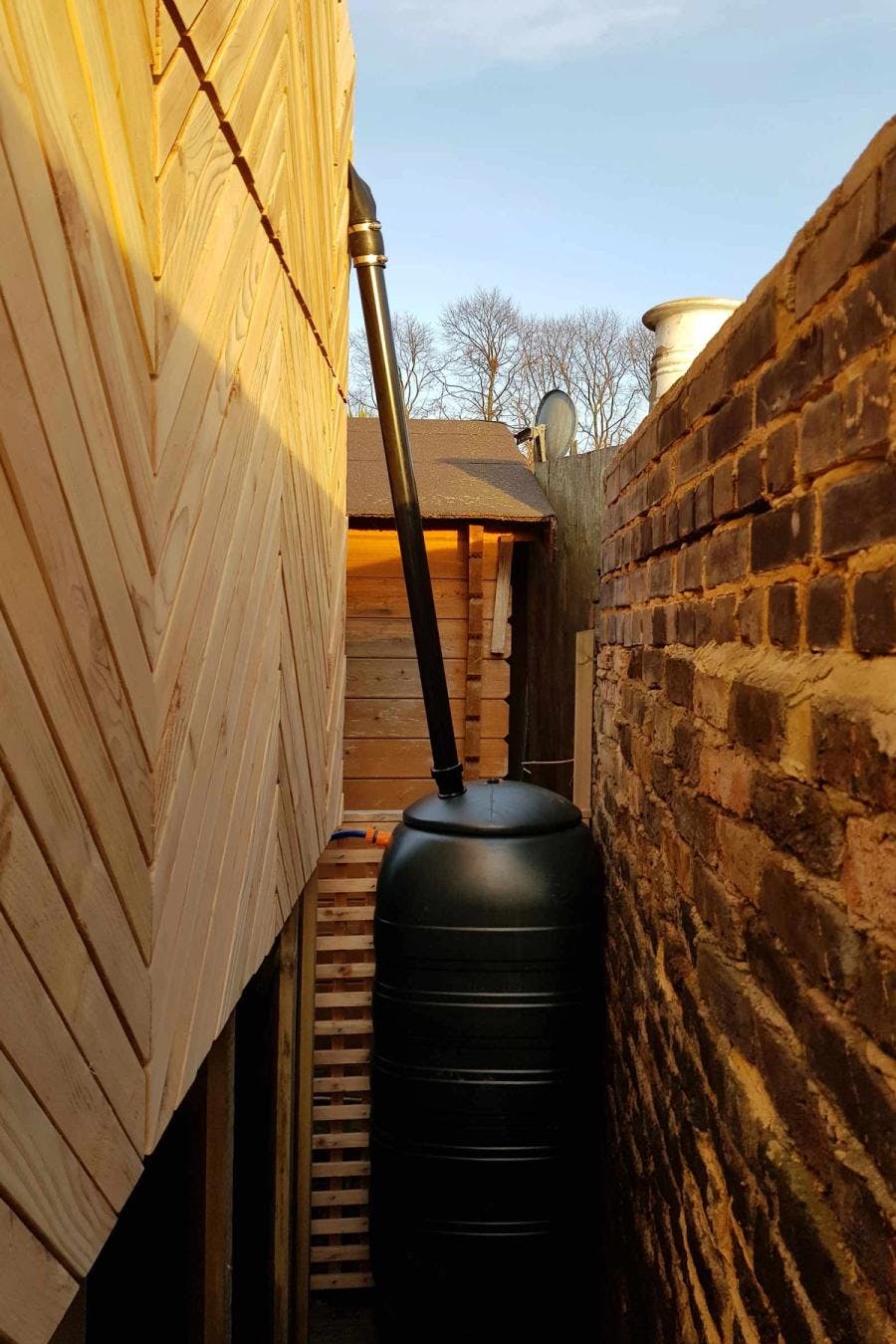 Rain water tank between the pod and brick wall