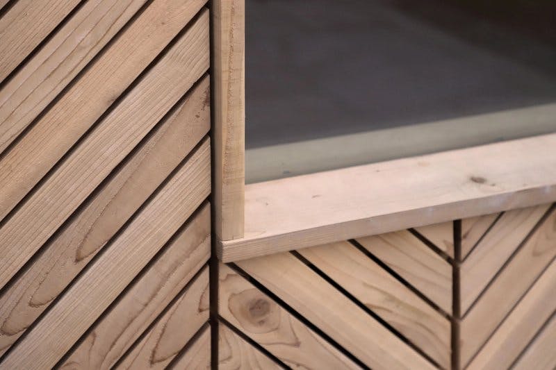 Close up of diagonal timber slat patterns that make up garden shed cladding