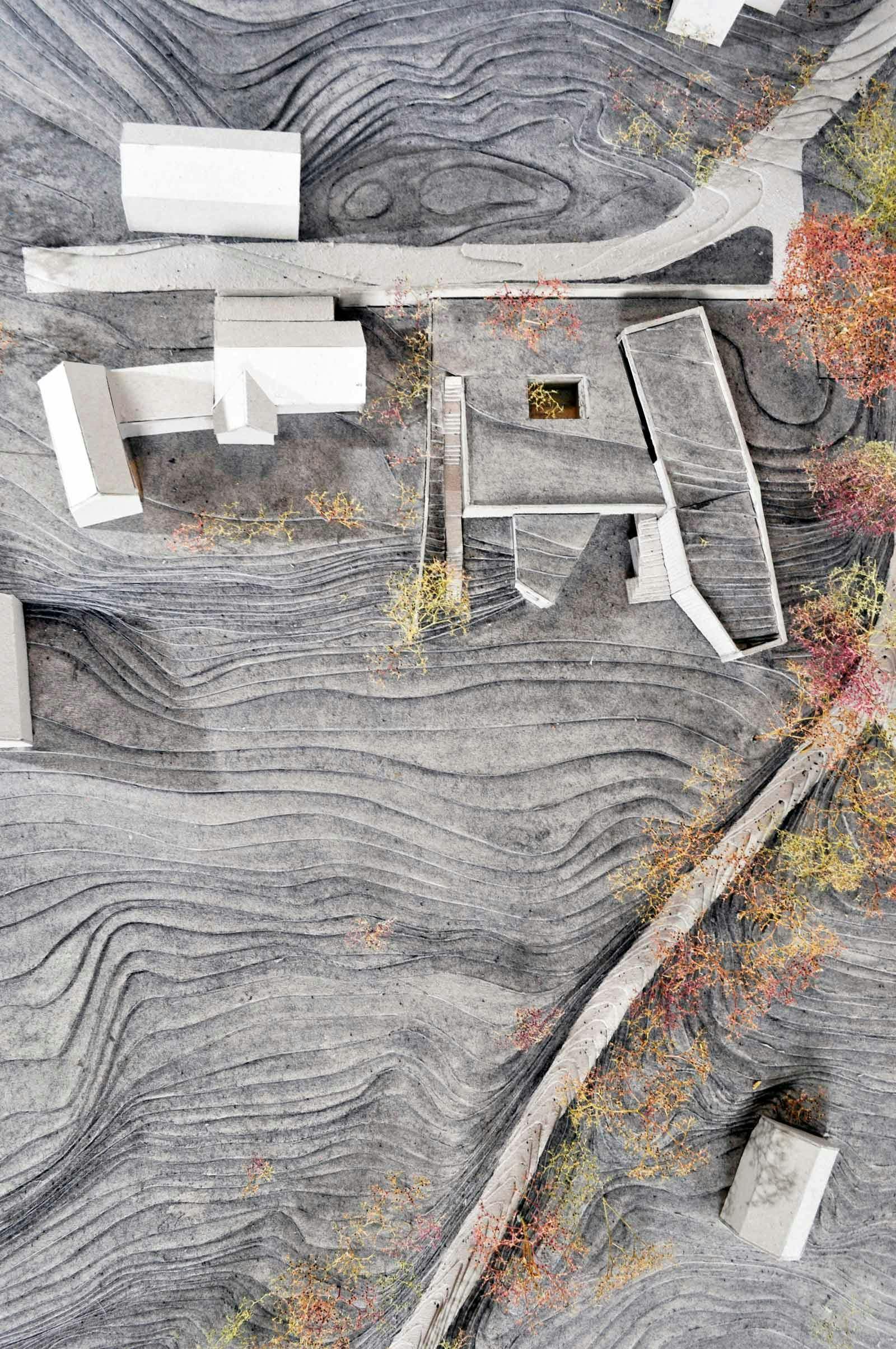 Architectural model with view from above of house embedded in landscape