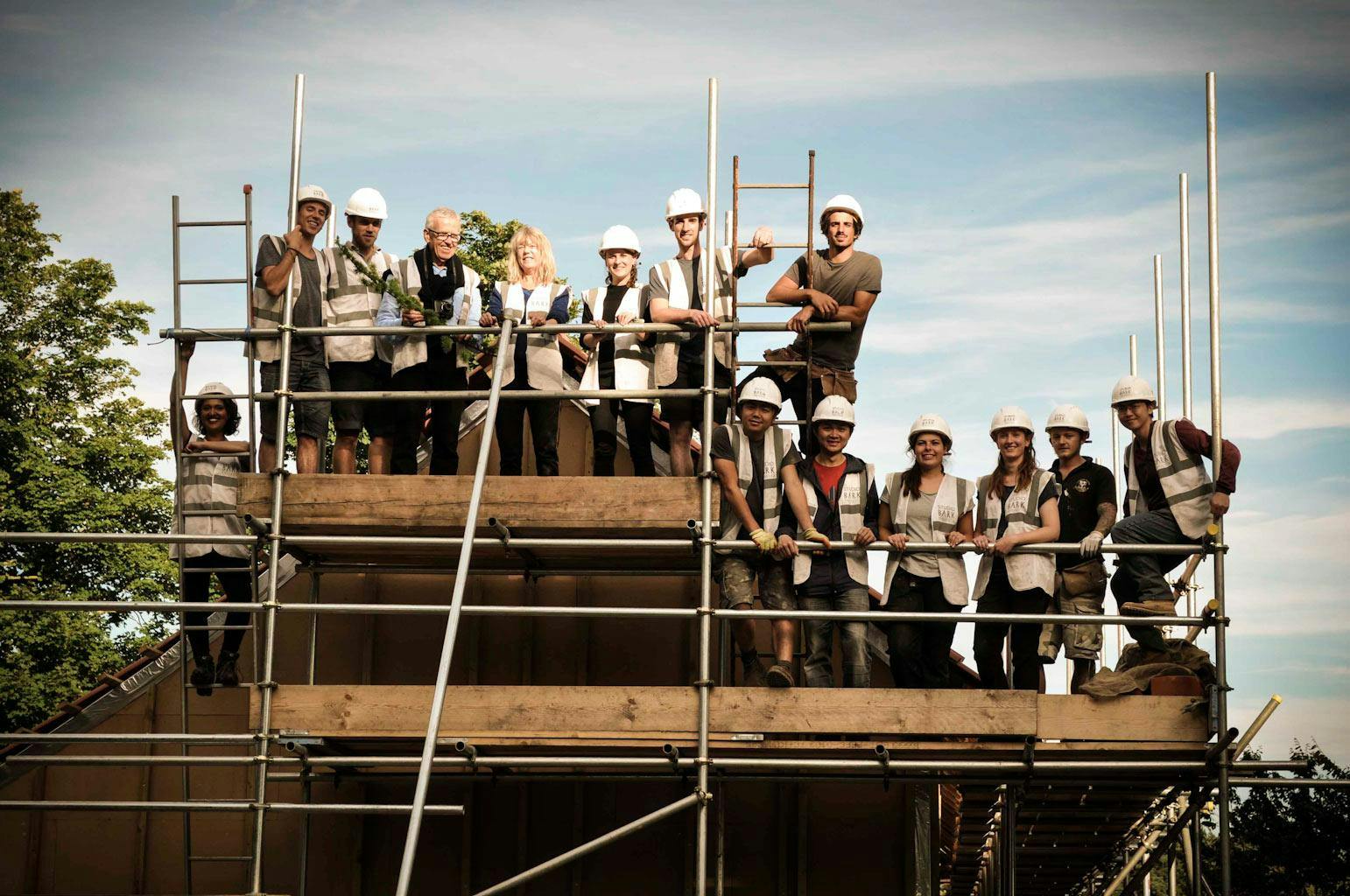 Image of students posing on building scaffolding